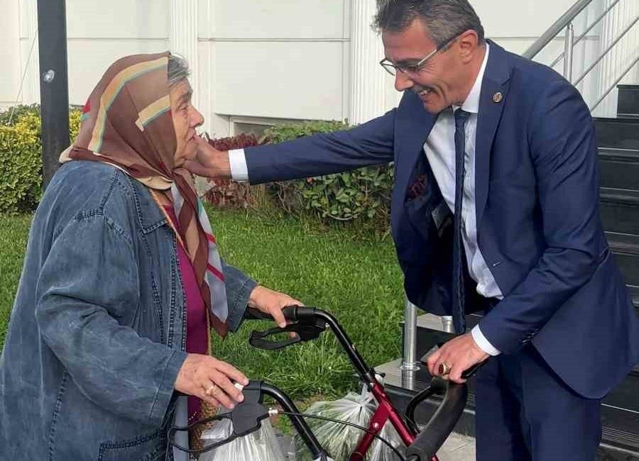 Erenler Belediye Başkanı Şenol Dinç, belediye bahçesinden elinde poşetleriyle geçen