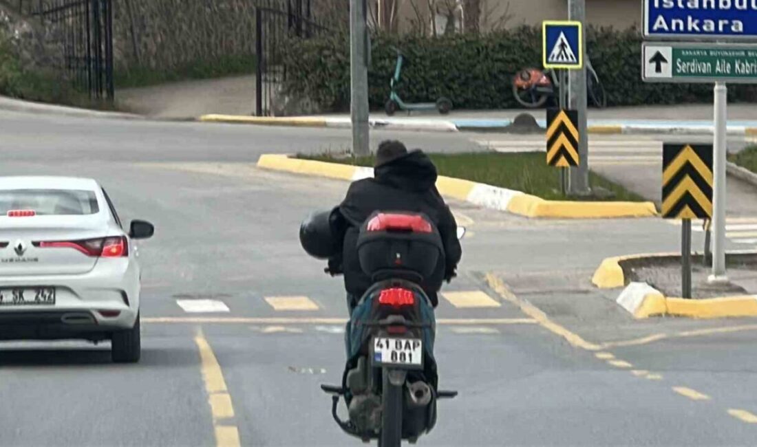 Sakarya’nın Serdivan ilçesinde motosiklet sürücüsünün kaskını takmak yerine koluna geçirerek